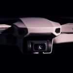 Detailed shot of a Mavic Mini drone showcasing its camera and design against a black background.